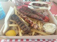 Grillteller mit Bifteki, Hähnchenspieß, Pommes, Pita, Tzatziki und Zitrone