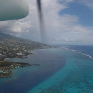 Blick aus dem Fenster der Twinottermaschine auf die Hauptinsel Tahiti wÃ¤hrend des Flugs von PPT nach MOZ